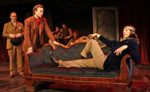 A man lies on a chaise lounge from the show Sherlock Holmes and the West End Horror.