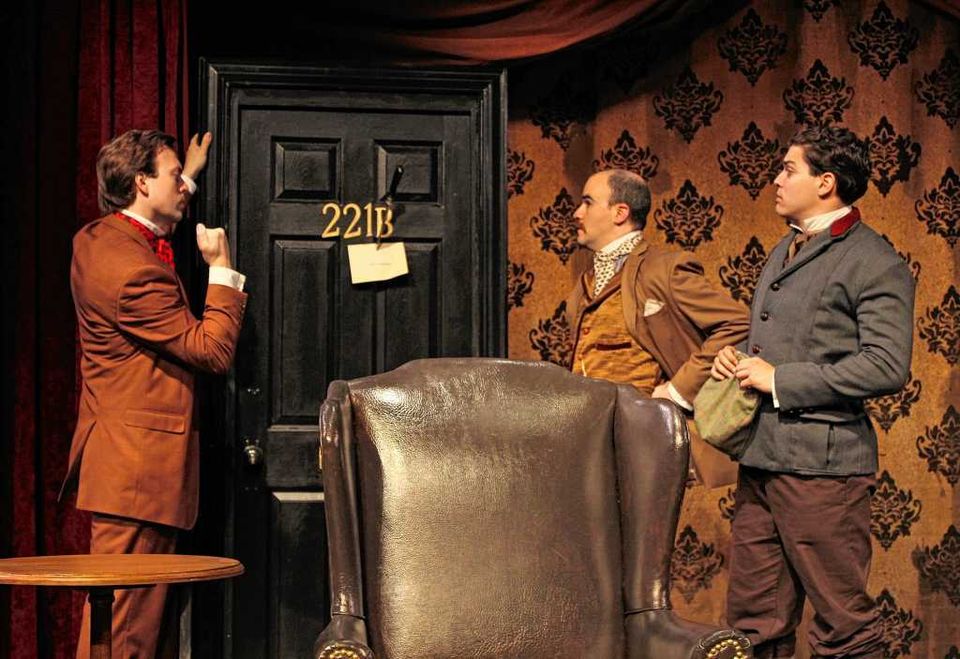 Three men start at a threatening note pinned to the door with a knife in Sherlock Holmes and the West End Horror.